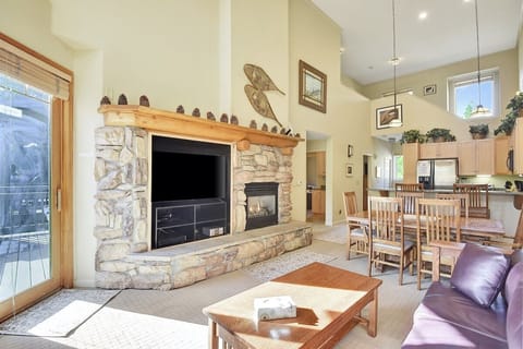 Bright living room with access to deck, a large TV & gas firplace