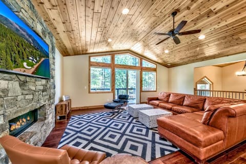 Unwind in your spacious living room with rich leather seating, a crackling fireplace, and soaring wood ceilings that create the perfect mountain retreat ambiance.