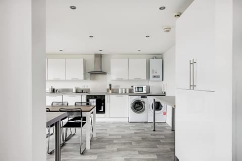 Kitchen: Sleek white cabinets and modern appliances for delightful meals and easy entertaining! 