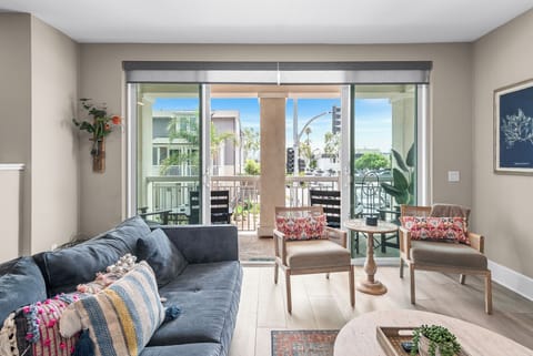 Bright and breezy living room with double doors that open to a private balcony, just one block from both the beach and bay. Perfect for soaking up the coastal air and sunshine!