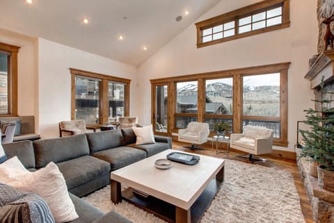 Living Room with plush sectional sofa, 65" Samsung smart tv, gas-assist fireplace, two separate seating areas, and private balcony access