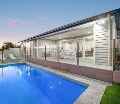 Fenced pool area sits beside the canal with water views.
