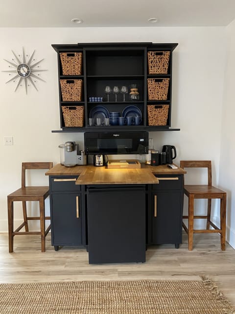 Kitchenette includes fridge, microwave, plates, utensils, glasses, silverware.