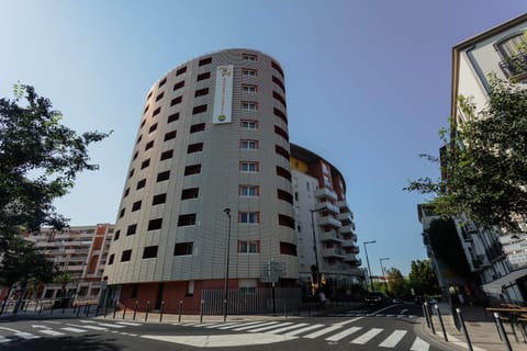 Tall cylindrical building showcases a modern architectural design against a clear sky