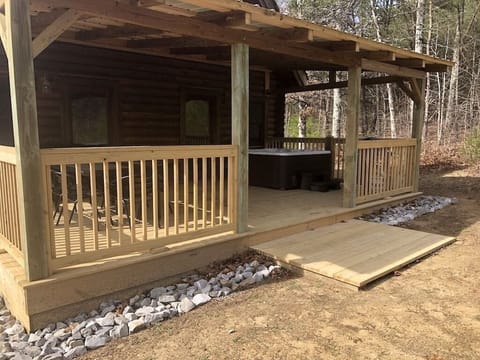Large back deck with hot tub, grill and seating.