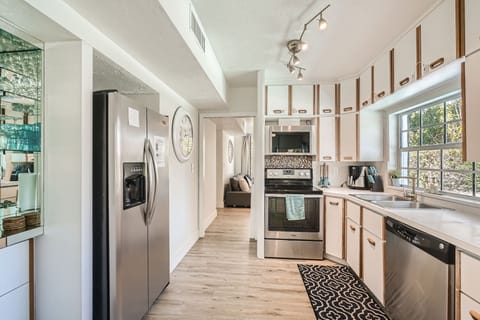 The bright kitchen is ready for memorable meals. Watch the family at the pool.