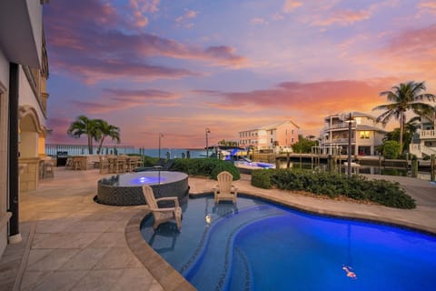 Waterfront pool, hot tub, and breathtaking sunset views over tropical waters.