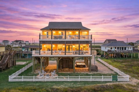 Beachfront Galveston vacation home at sunset with elevated design, large balconies, and direct beach access.
