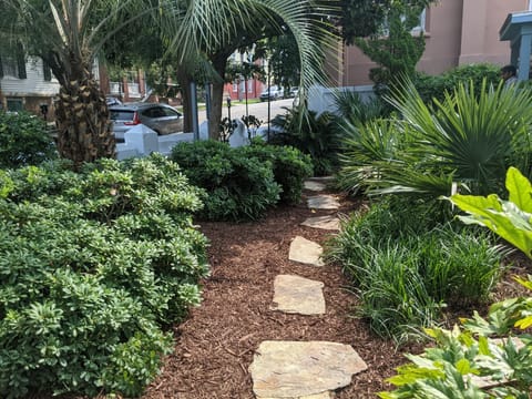 Lush gardens and meandering pathways surround the house