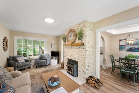 Relax by your cozy stone fireplace while natural light fills the spacious living room, creating a perfect gathering space for memorable moments.