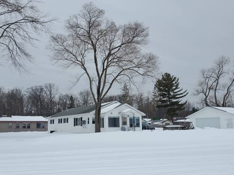 A view of the cottage from the frozen lake looking back at it and the garage.