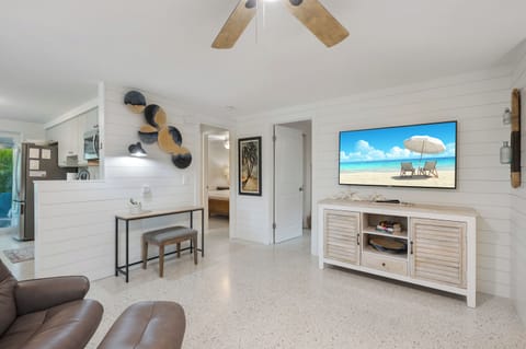 The living room features a desk and a Smart TV