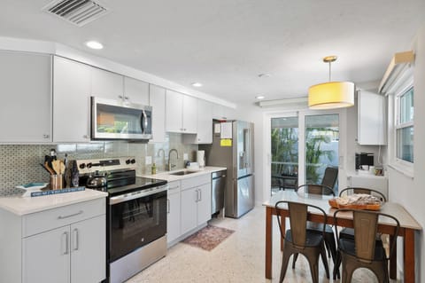 Full size refrigerator in the kitchen and glass doors leading to the screened lanai