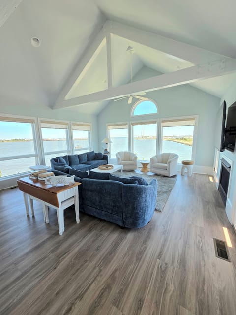 Spacious gathering space with large screen TV, fireplace, comfy sofas and water views. 