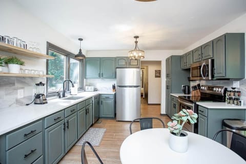 Fully stocked kitchen with Quartz countertops and tile backsplash, stainless appliances, double refrigerators, and eat in dining area.