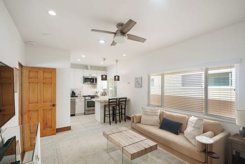 The living space features a Smart TV, dining island and a dedicated workspace.