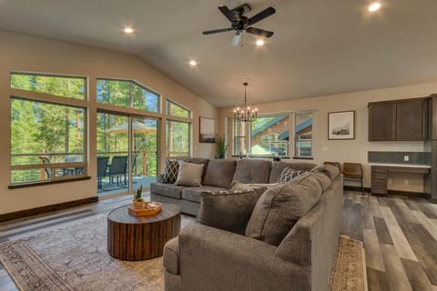 - Cozy living room with forest views  
- Large sectional and rustic decor  
- Sliding doors to outdoor deck