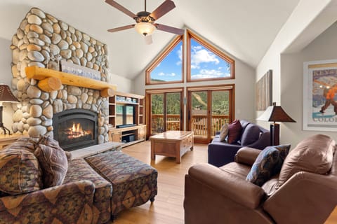 Relax in this inviting living room where vaulted ceilings, a stunning stone fireplace, and mountain views create your perfect mountain retreat.