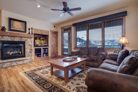 Sink into plush leather sofas beside your crackling fireplace, where mountain views through oversized windows create the perfect backdrop for cozy evenings.