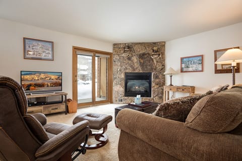 Cozy up in your inviting living room with plush seating by the stone fireplace, perfect for après-ski evenings.