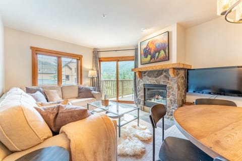 Sink into plush sofas by your stone fireplace while mountain views frame your perfect retreat through expansive windows.