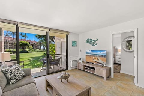 Spacious living room offers cozy seating, beachy accents, and direct access to a scenic patio retreat