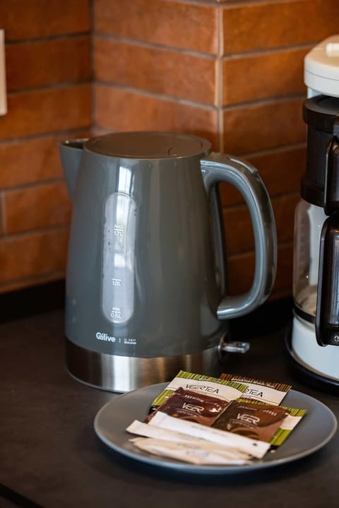 Close-up of an electric kettle next to which lies a tea plate.