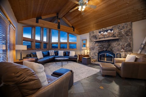 Unwind in your spacious living room where leather seating and a stone fireplace create the perfect mountain retreat atmosphere.