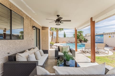 Large backyard with plenty of patio seats and a private swimming pool