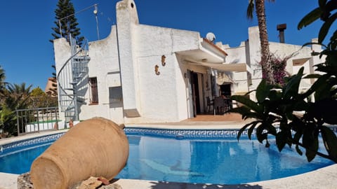 A beautiful overall shot of the 8.20m pool looking towards the modern architecture of House Noella and the shading awning.