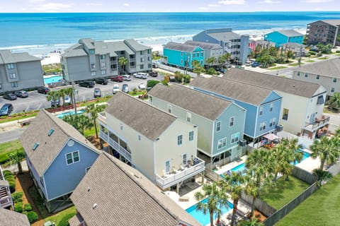 Coastal vacation rental community featuring colorful beach homes with pools and easy beach access in a vibrant oceanfront neighborhood.
