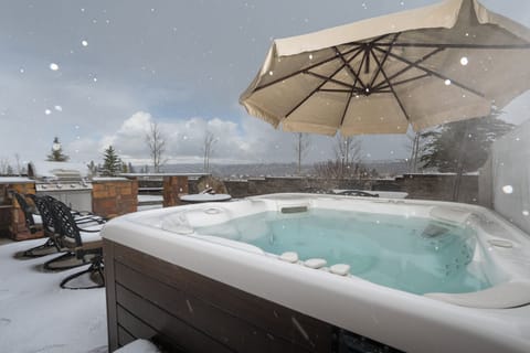Soak in the steaming hot tub as fresh snowflakes drift down around you, while distant mountain slopes stretch across the horizon. Pure winter magic.