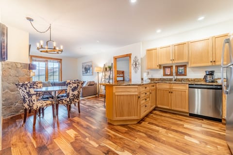 Your spacious kitchen flows seamlessly into the cozy dining area, where warm hardwood floors and granite countertops create the perfect space for cooking and gathering.