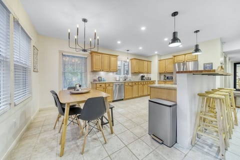Kitchen with modern appliances, breakfast table, and island bar