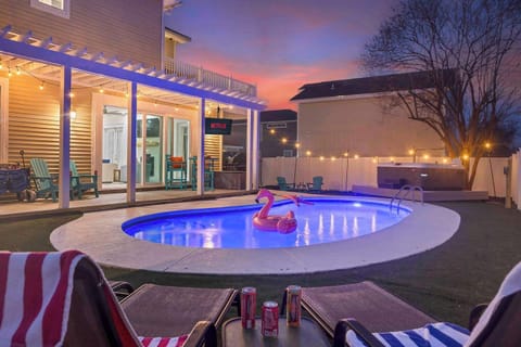 “Evenings in your private backyard oasis — pool, hot tub, Outdoor TV and string lights under a Destin sunset.”