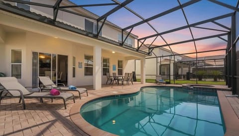 Screened-in private pool with lounge chairs, a spa, and a shaded patio for relaxation.