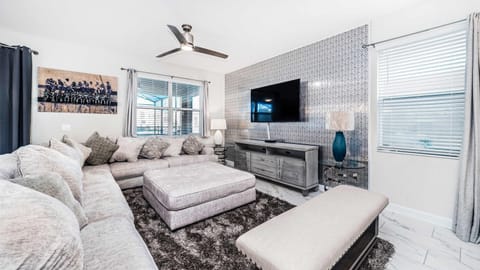 The expansive living room beckons with its generous space, adorned with a plush and inviting sofa, creating an ideal setting for cherished family reunions.