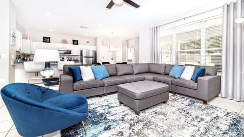 Modern living room with stylish gray sectional and vibrant blue accents.
