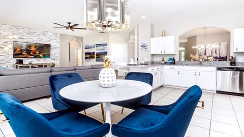 Chic open-plan space with luxe blue chairs and a striking white marble table.