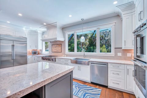 Fully stocked kitchen with stainless steel appliances.