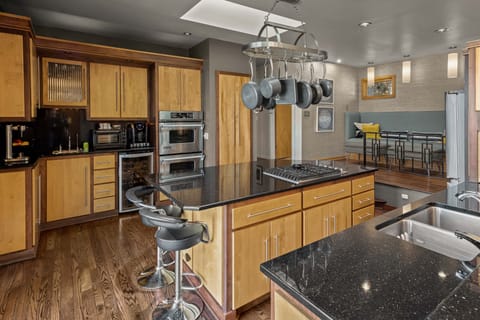 Kitchen island with view of bar and double ovens. 
