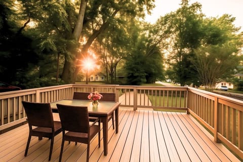 Dine on the deck at golden hour surrounded by leafy trees.
