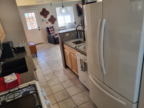 Kitchen facing Living Area with large side-by-side Refrigerator & new dishwasher