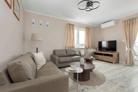 A bright living room with a comfortable sofa, armchair, and a coffee table placed on a rug.