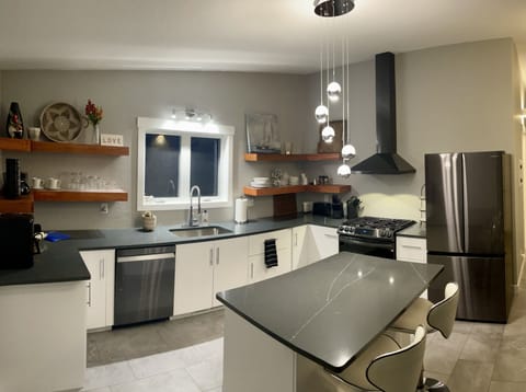 Bright kitchen with quartz counter tops and island seating for 2.