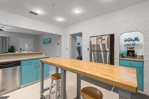 [Kitchen] Rest easy with a large fridge and dishwasher, along with seating for two more.