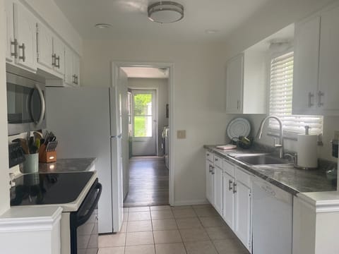 Fully stocked kitchen with new refrigerator, microwave, small appliances.