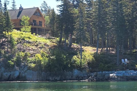 Log cabin above the water overlooking the ocean.