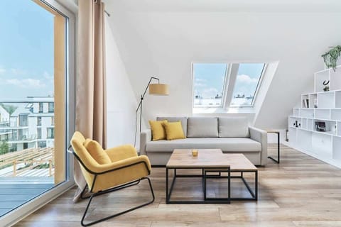A bright living room with a skylight, modern furniture, and a cozy yellow armchair, creating a welcoming atmosphere.