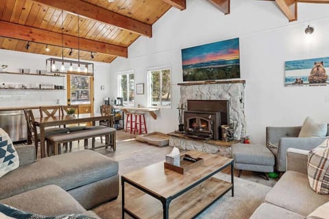 Main living area. Sofa with chaise, love seat, arm chair. Wood burning fireplace. 65 inch smart tv. 
